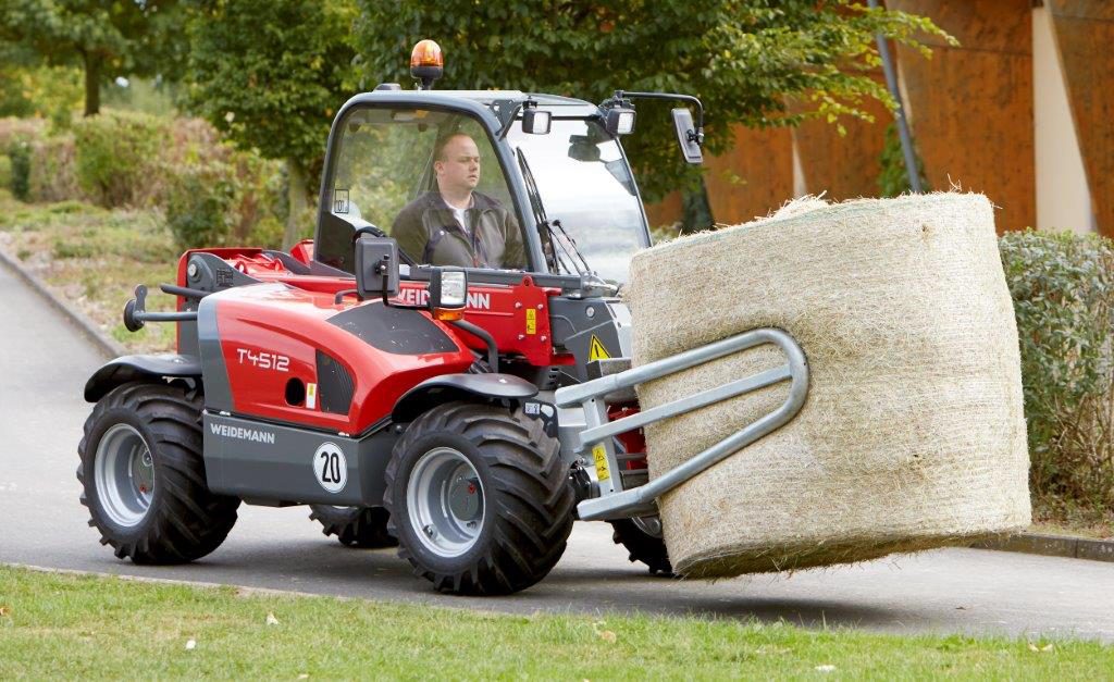 A Weidemann T4512 scooting about with a round bale