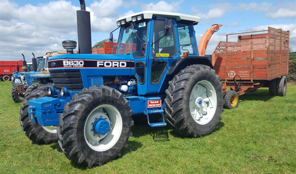 Many Ford 8630s (132hp) had a Funk full powershift transmission. This example had the more basic Dual Power gearbox. It had a harvester and a locally-built Lee trailer in tow