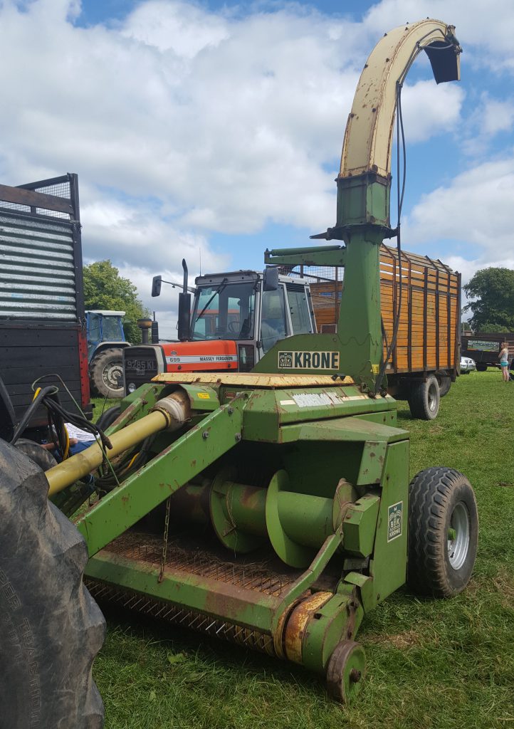 This Krone in-line, precision-chop forager was one of the more unusual trailed harvesters present at the event. This machine was teamed up with a 110hp Ford 8210 tractor and filled trailers in a variety of configurations. At one point during the day, it was blowing grass into a tractor (MF 135) and trailer running directly behind the harvester. Later on, it was side-filling the same tractor and trailer combination (with the ‘little’ 135 running alongside the ‘big’ Ford)