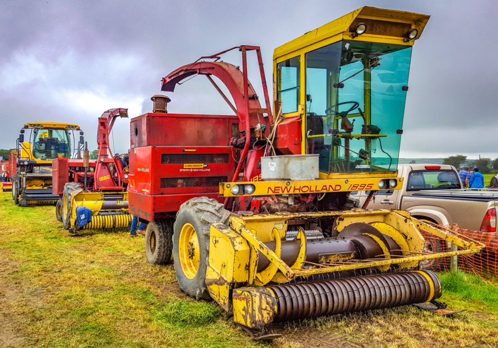 Old and new: A New Holland 1895 sits in the foreground; an older 1880 is nestled behind; and a positively modern FR9050 brings up the rear. This event provided an opportunity to compare New Holland foragers from different eras
