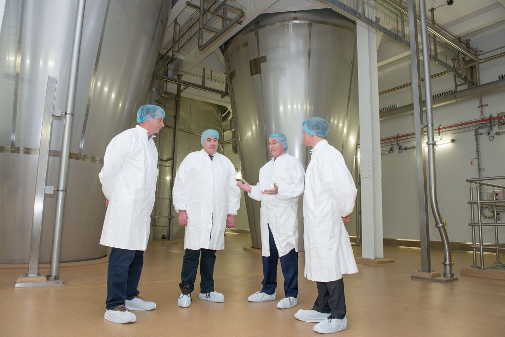 Gabriel D’Arcy, LacPatrick’s Chief Executive explains how the two cyclones, pictured behind the group, allow the plant to make infant milk formula
