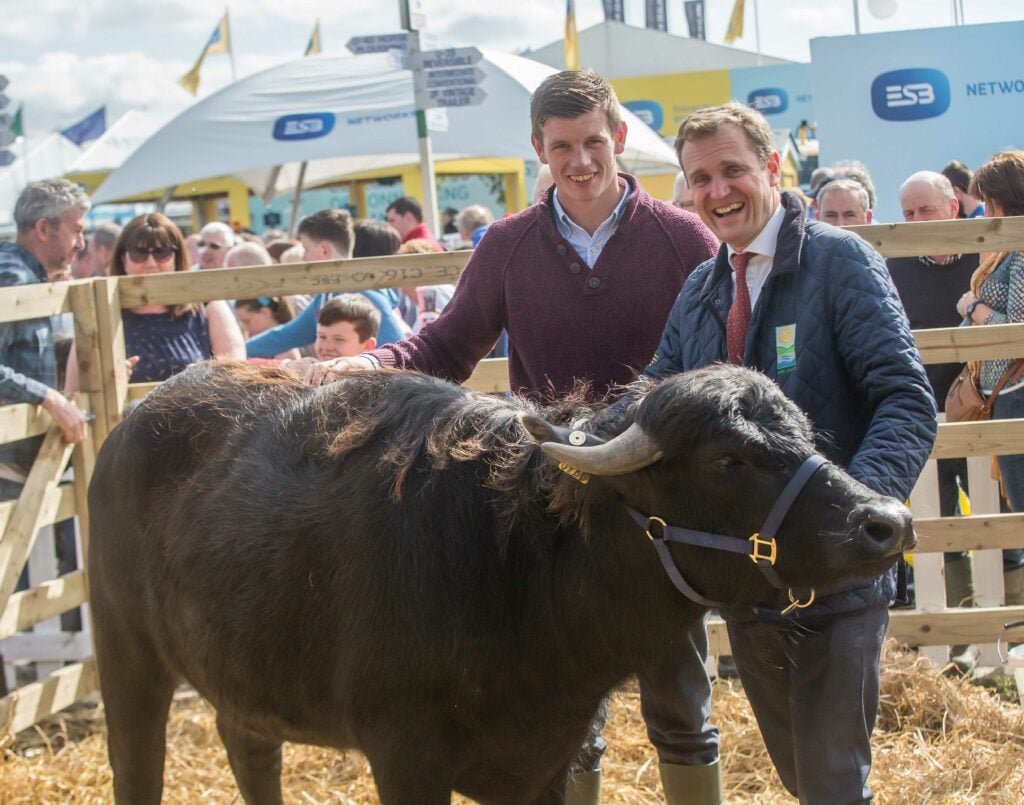 John Heslin, Westmeath footballer, with Richard Moran, chairman, Agri Aware, and Susie the buffalo during the National Ploughing Championships. Image source: Pat Moore