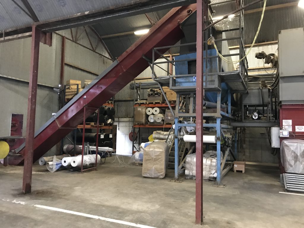 Chopped straw going up the conveyor belt to the sieve
