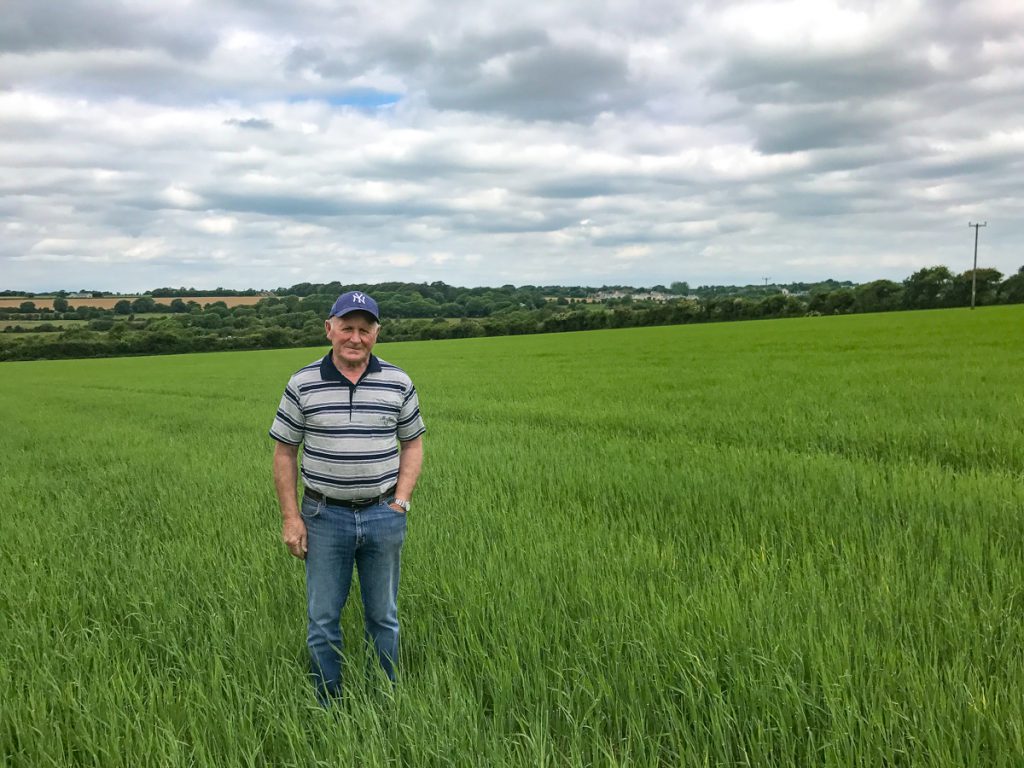 Frank Murphy standing in a crop of Planet spring barley on his farm in Co. Wexford