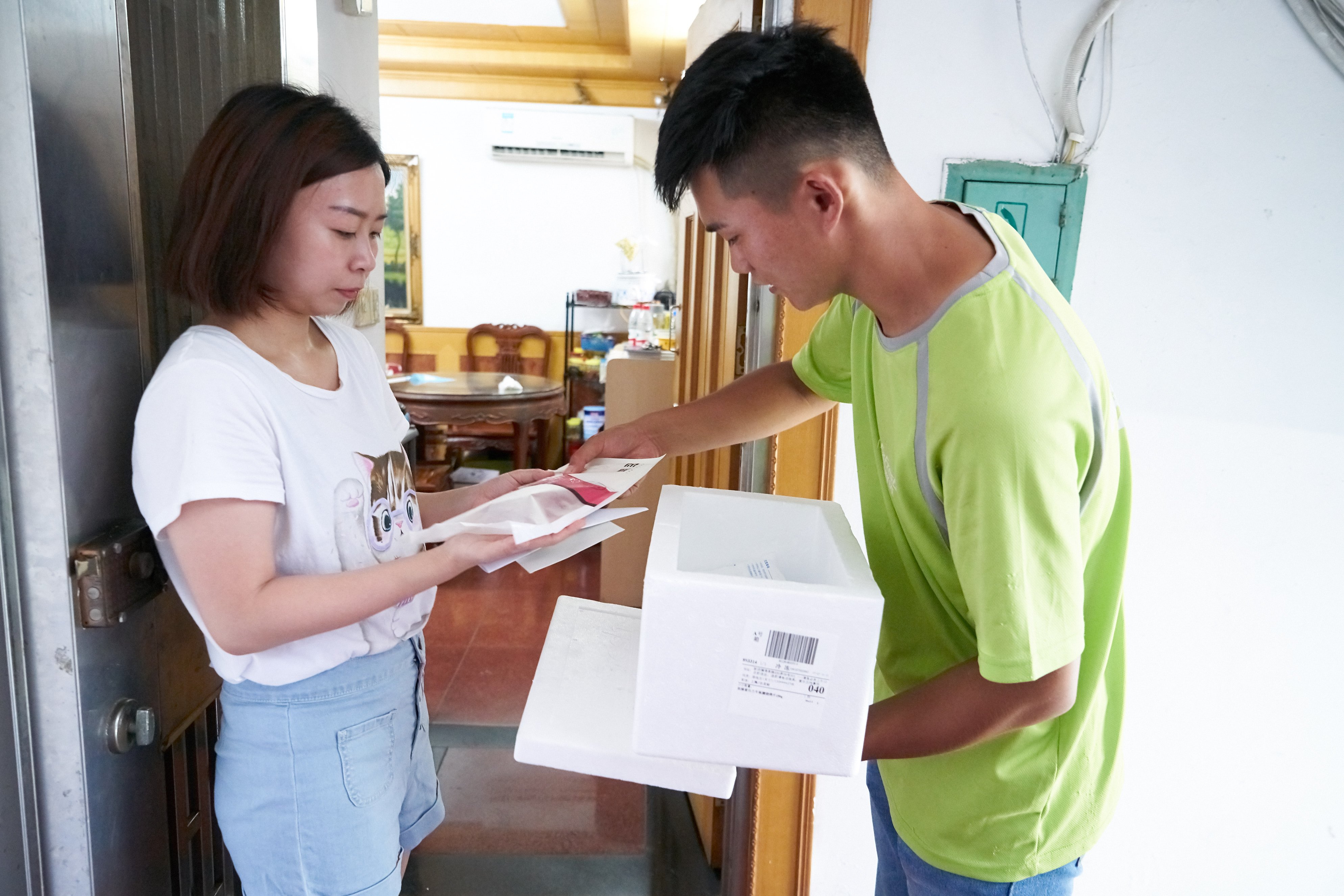 Miss Xu from Shanghai pictured here receiving her online delivery