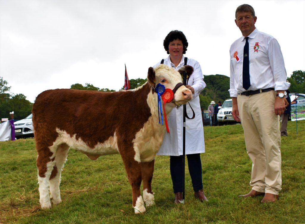 Reserve Heifer Calf Champion ‘Glosterbegpoll 1 Sheeba’ with owner Davina Lewis and judge Glenn Jacob