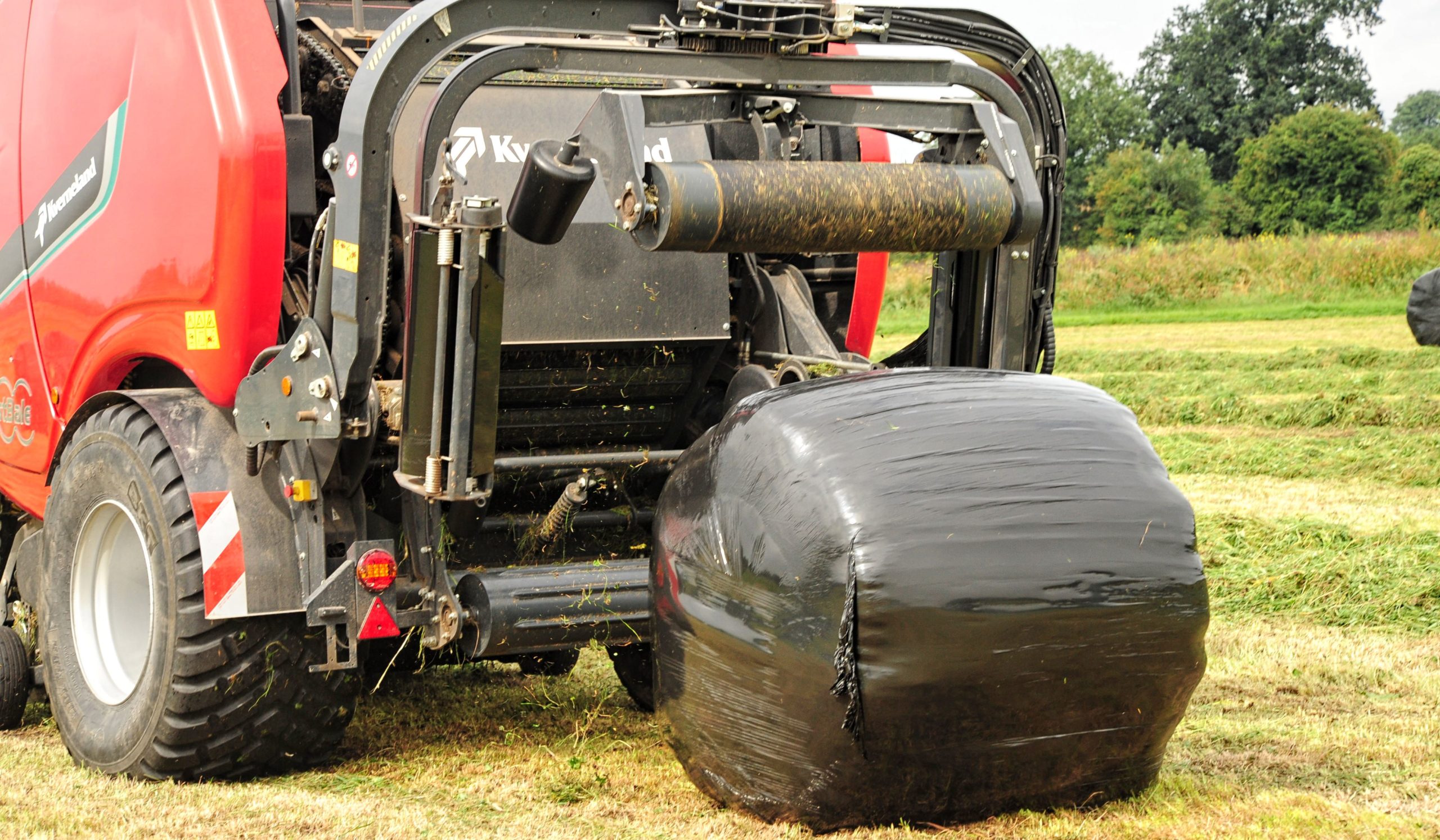 The wrapping frame lifts up to drop the bale without the tractor needing to stop