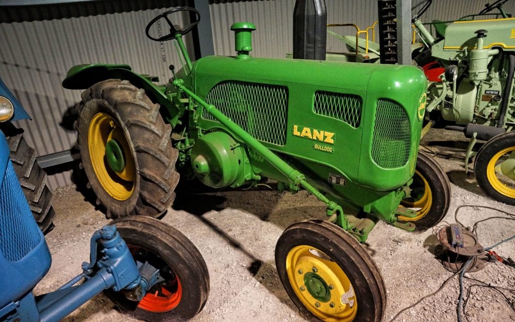 This 24hp orchard model has the Lanz name and John Deere livery. The hinged drivers seat can be seen folded out of the way to aid ingress