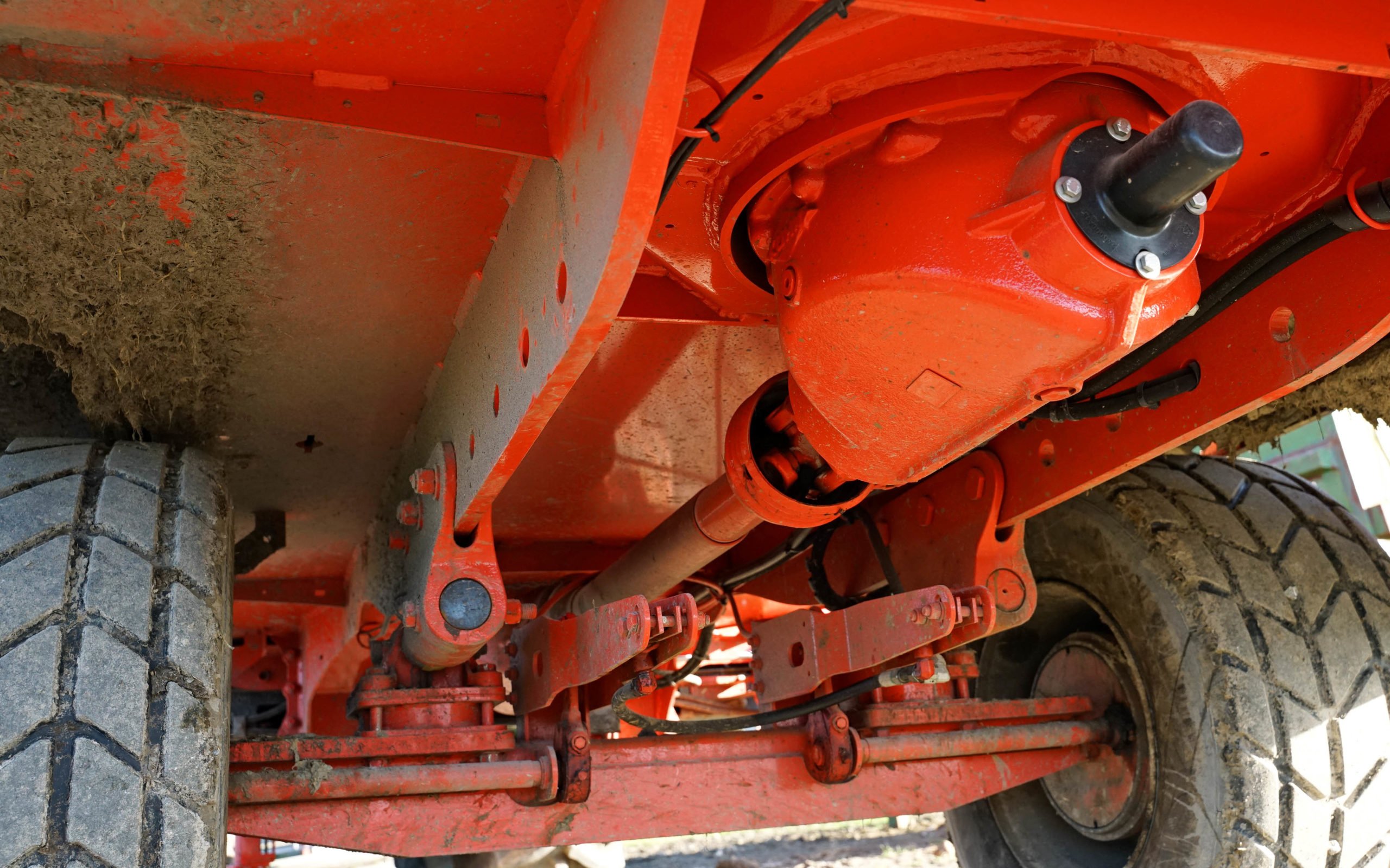 The bottom plate of the mixer forms the chassis with the axles attached by subframe. The left had weigh cell is located behind the black disc