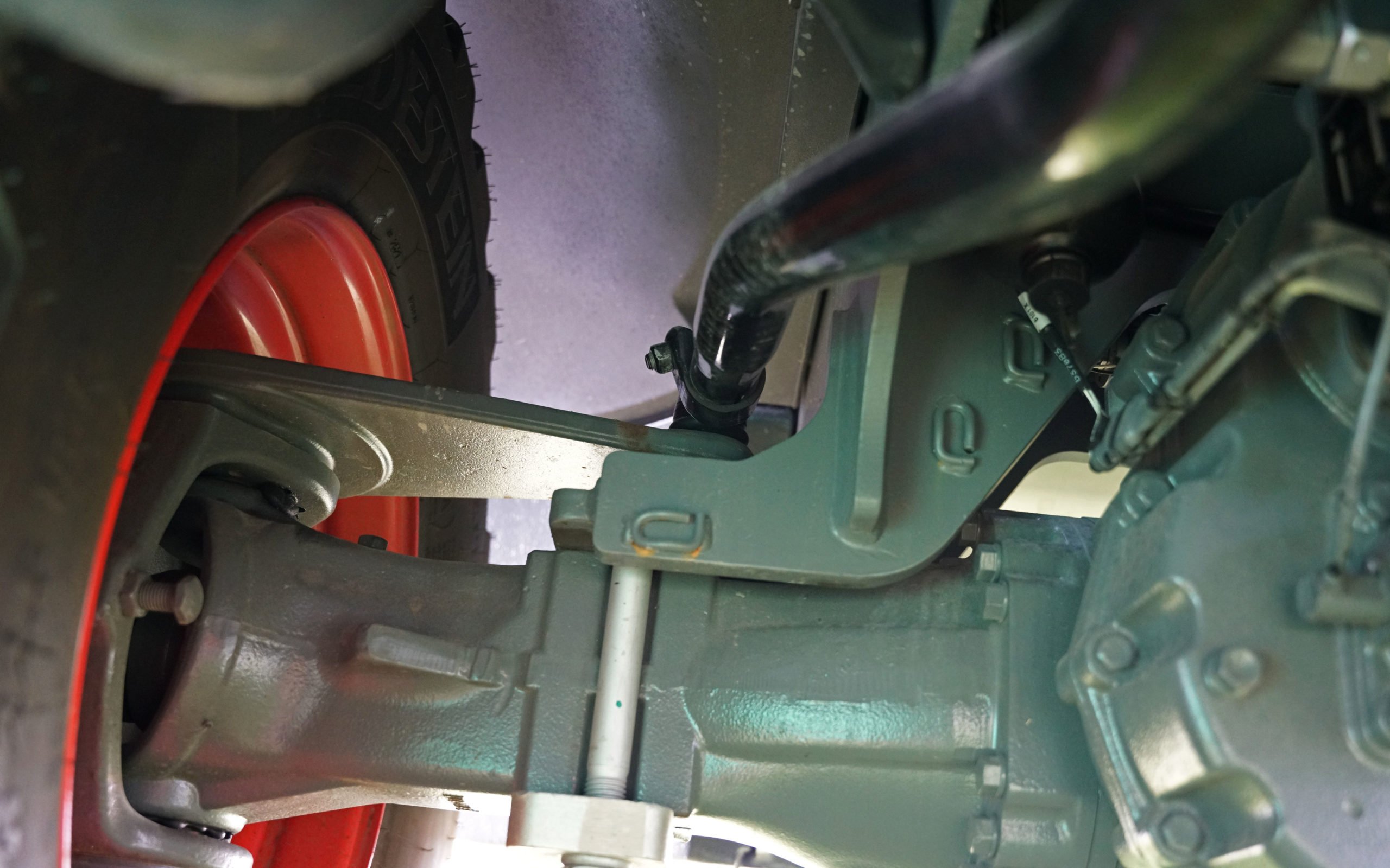 A steering rod from the front half of the loader turns the rear wheels when articulating