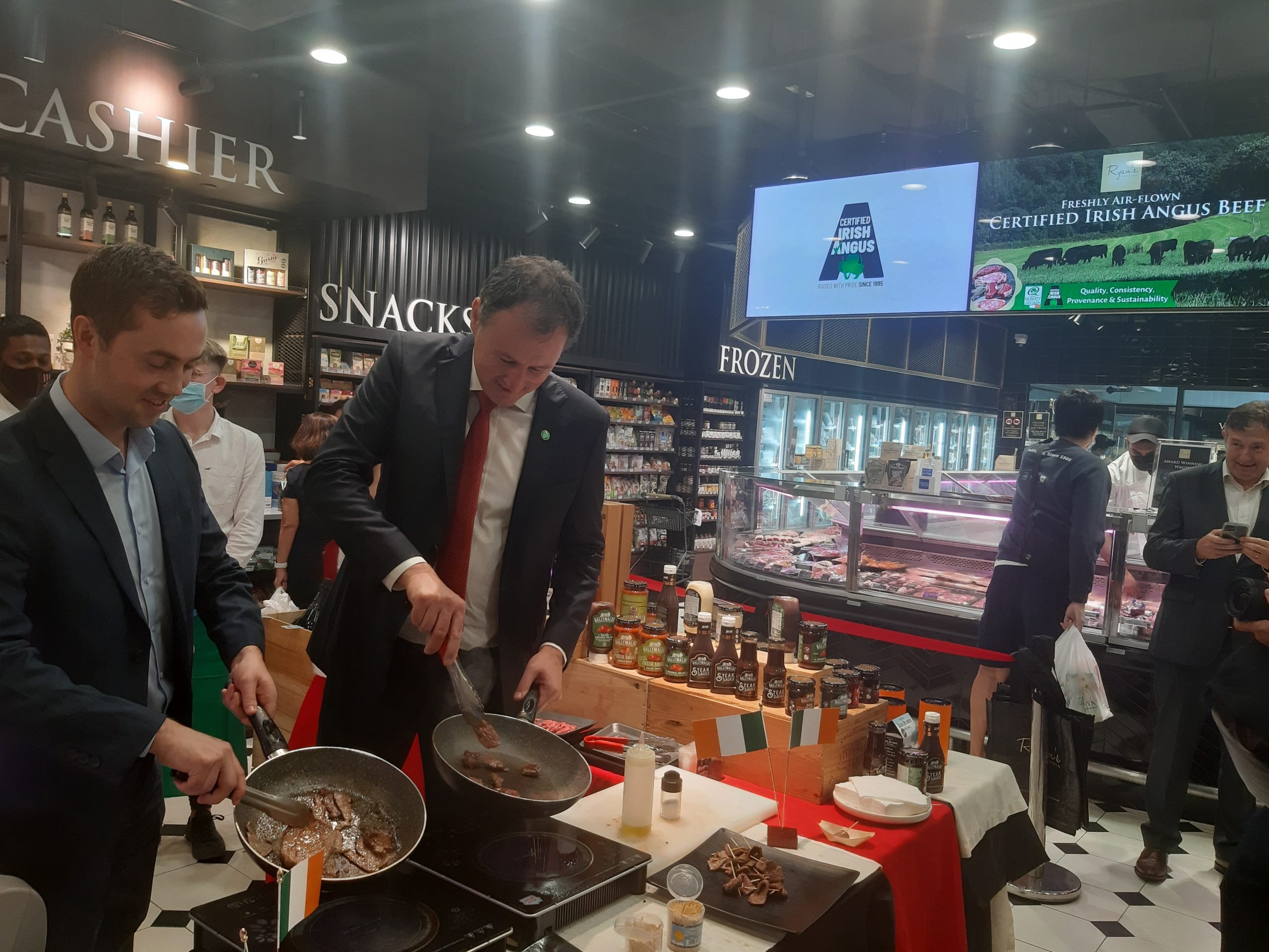 Ciarán Gallagher, Bord Bia director Southeast Asia and Minister for Agriculture, Food and the Marine, Charlie McConalogue cooking Irish beef in Ryan's Grocery