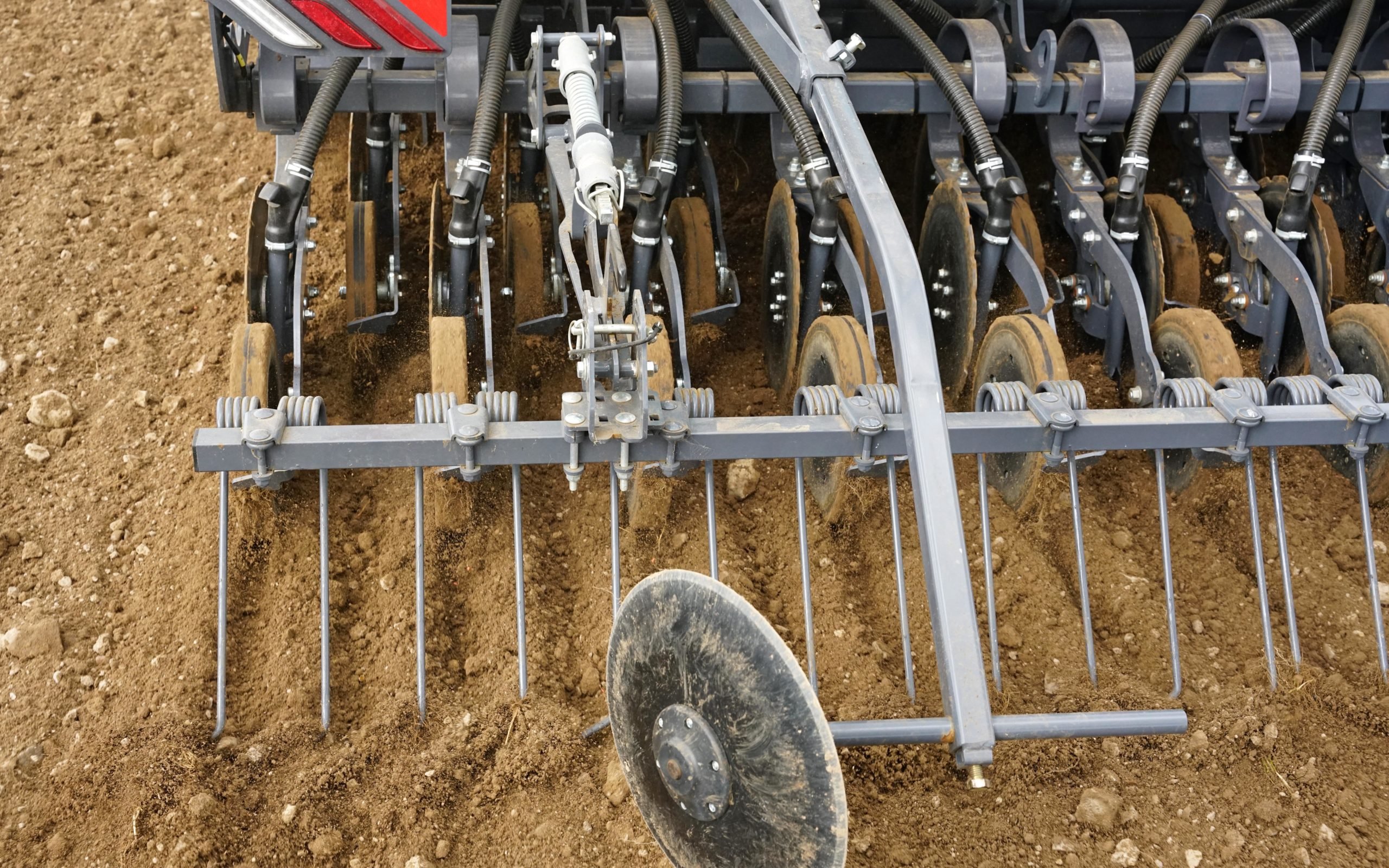 By running at a slight angle the disc creates a slit which is opened by the coulter chute, down through which the seed passes before consolidation by the press wheel