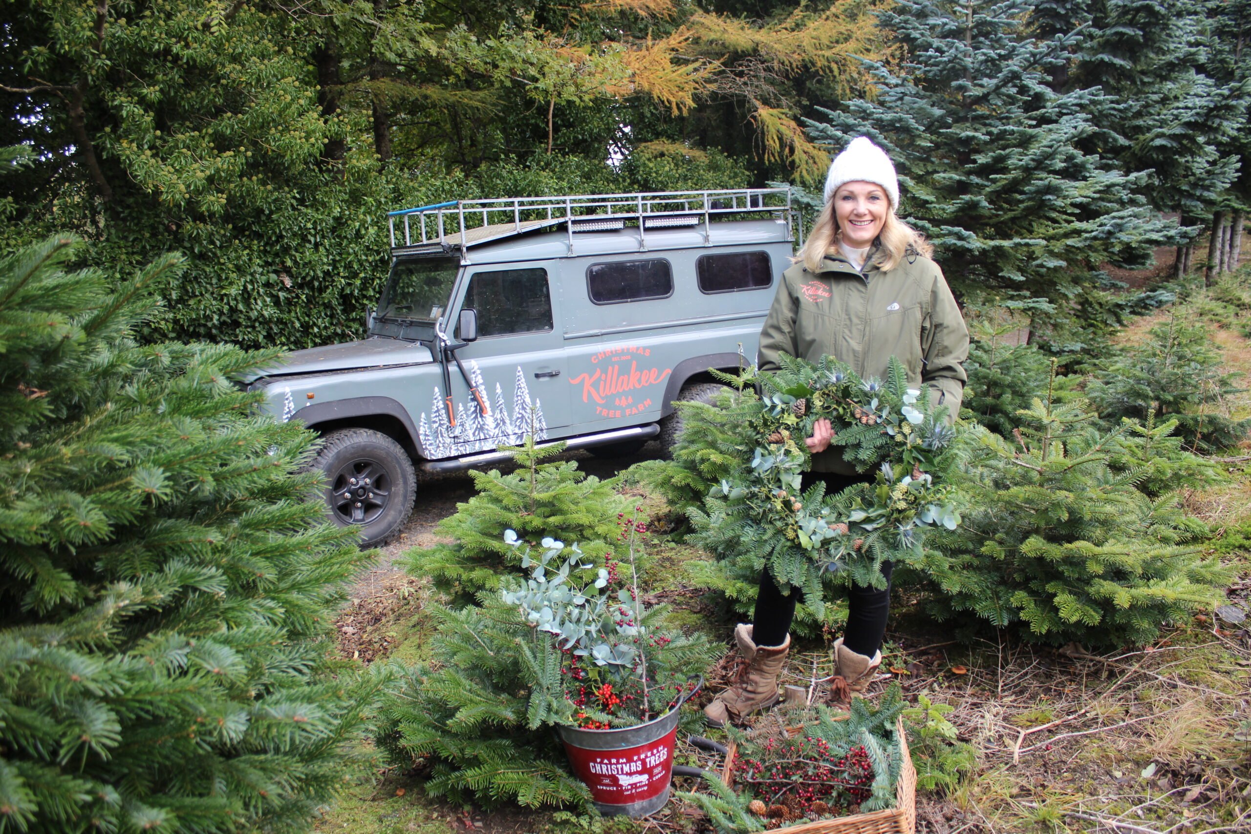Karen at Killakee Christmas tree farm holding a festive wreath handcrafted on the farm using tree off cuts,  and holly or ivy from the farm. Image source: Killakee Christmas tree farm