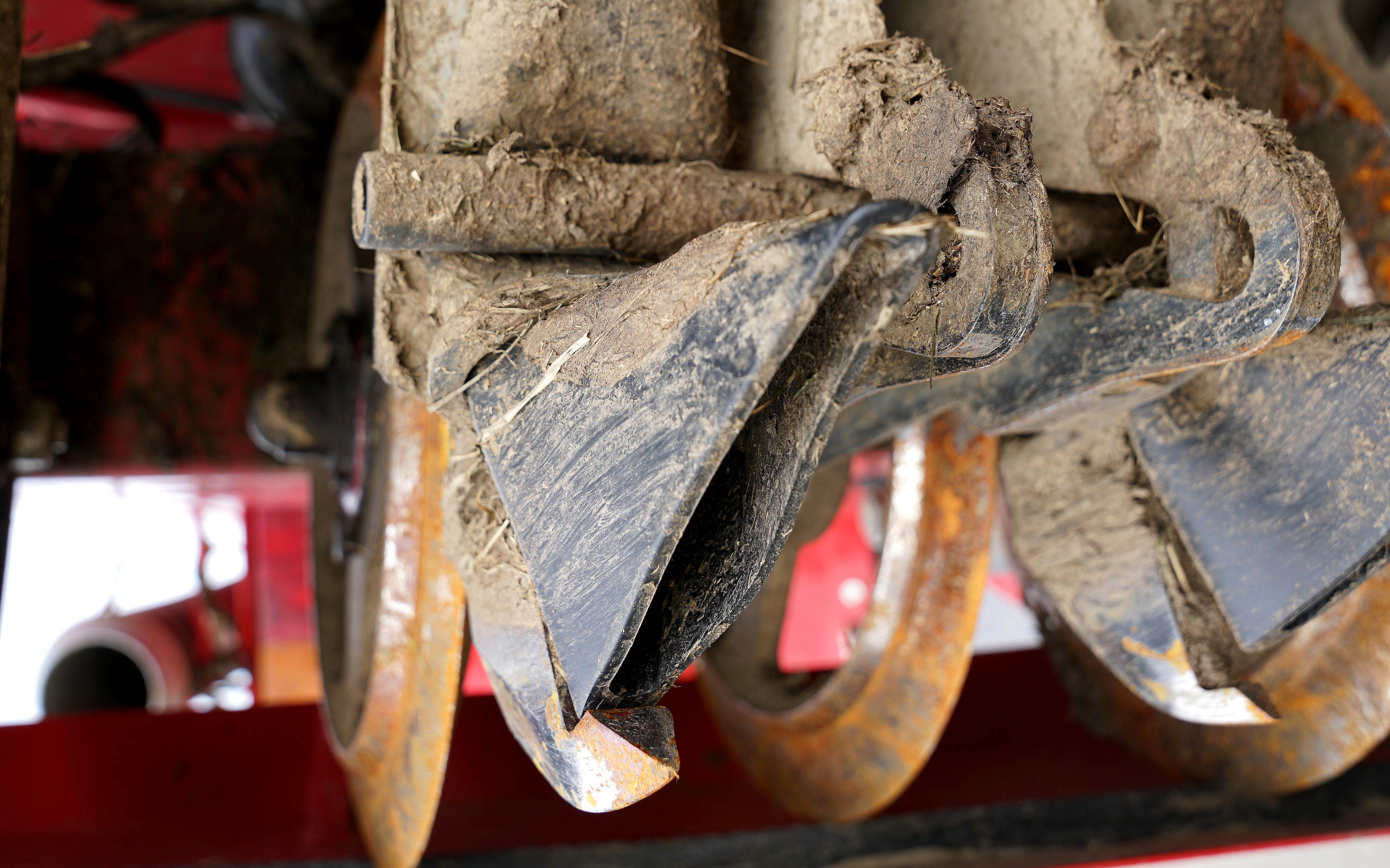 The disc cuts a slot which is opened by the blade, immediately following the blade is the boot which discharges the slurry into the slot. A round bar pinching the feed tube prevents flow when raised from the ground