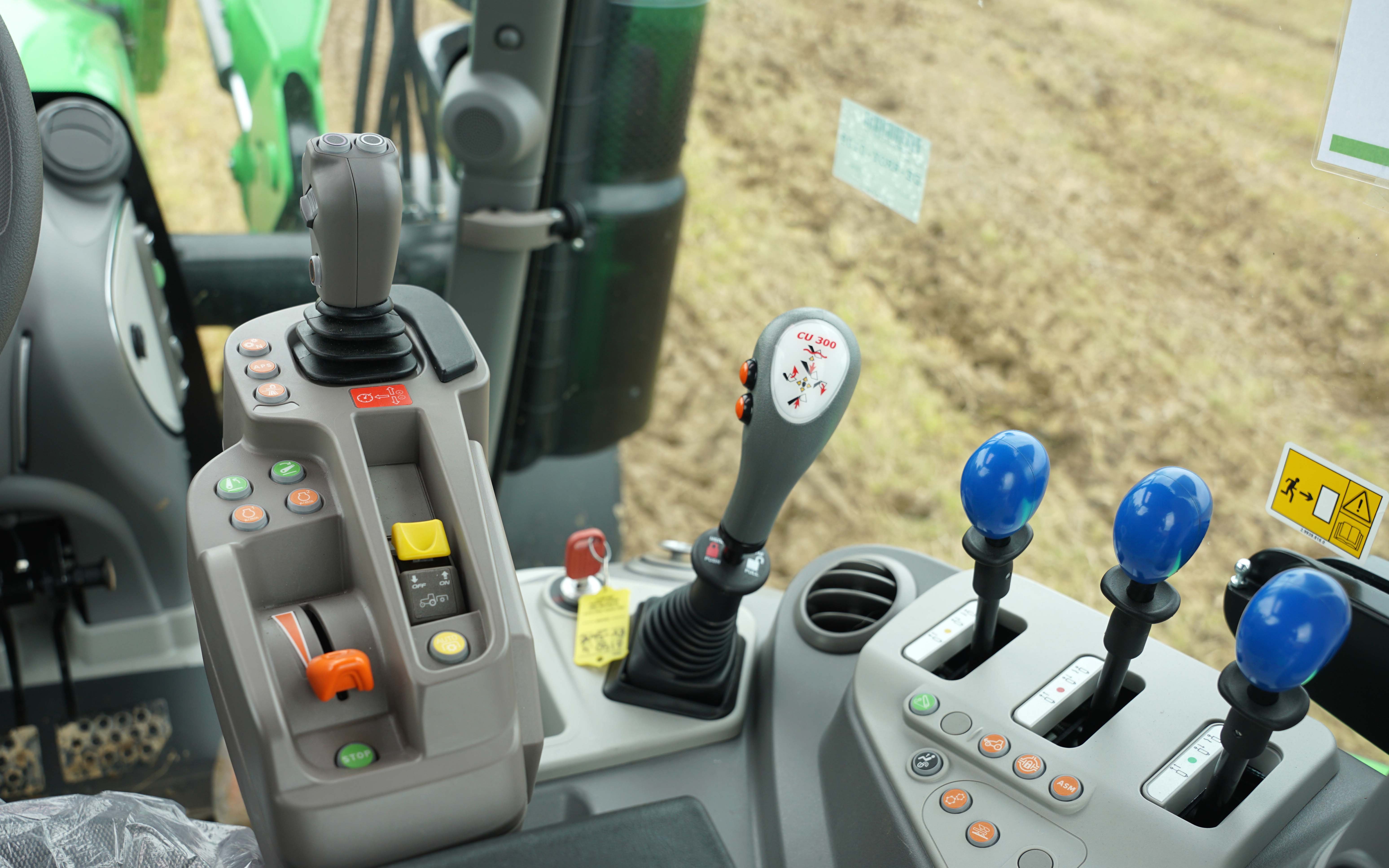 The single joystick gear selector (far left) for the RV transmission is situated on the armrest in the 6.4 series tractors