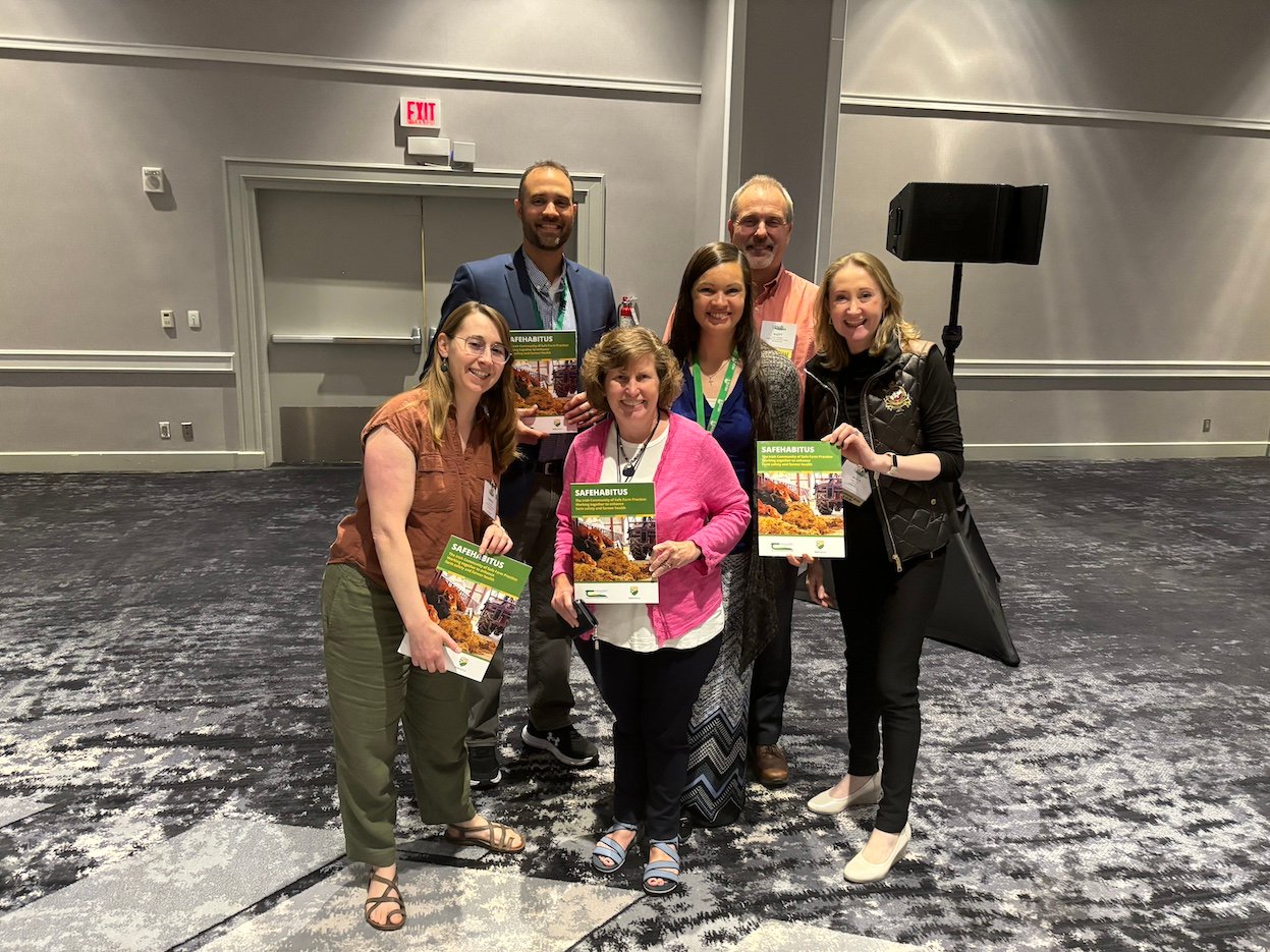 Alma Jordan, on right, sharing the SafeHabitus book with Dr. Bryan Weichelt, Scott Heiberger, Melissa Ploeckelman from the National Farm Medicine Centre, Dr. Florence Becot and Linda Fetzer, University Pennsylvania