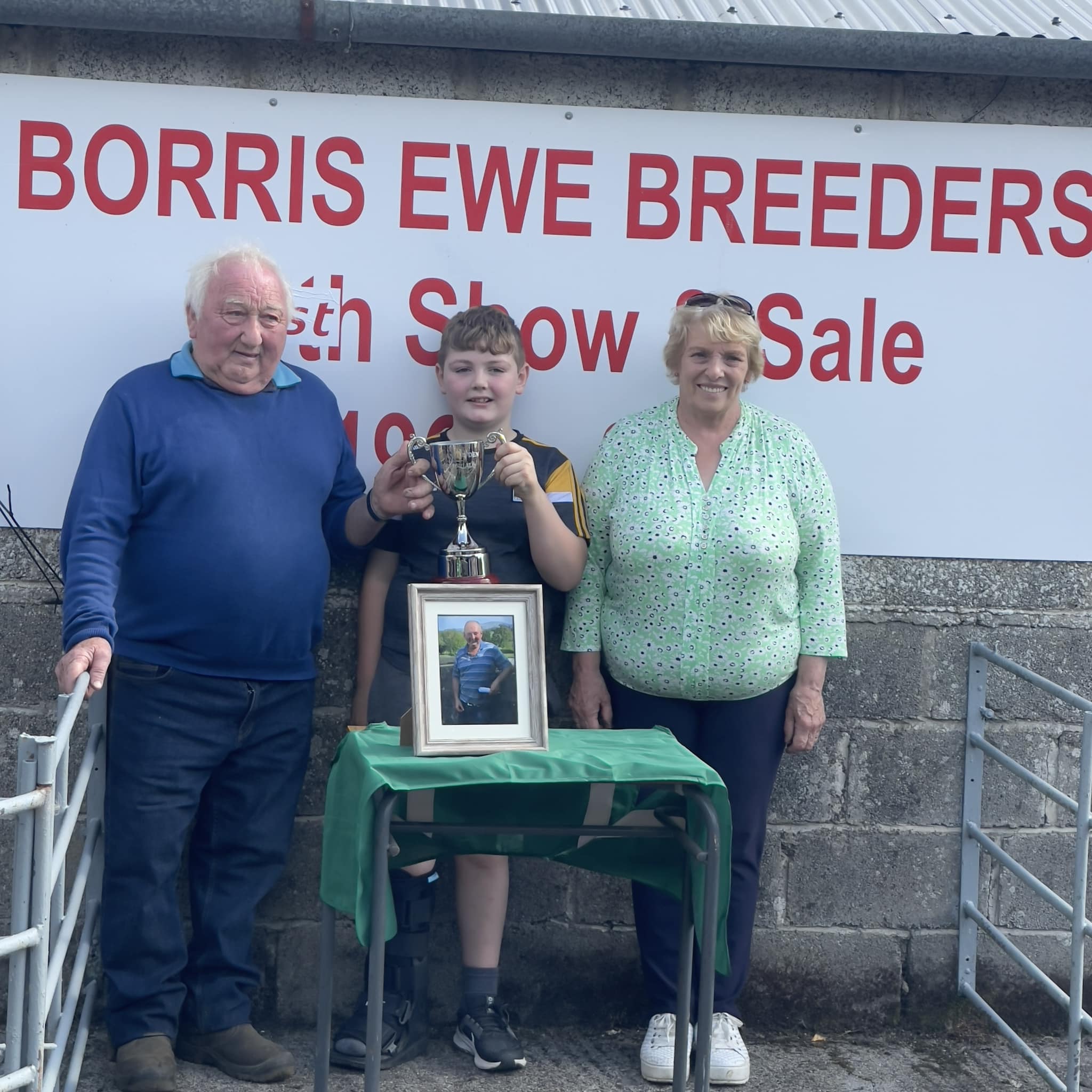 Pat and Catherine Hayden with their granson, Dara Fenlon with the Adrian Hayden memorial cup and a photo of the late Adrian Hayden Source: Borris Ewe Breeders