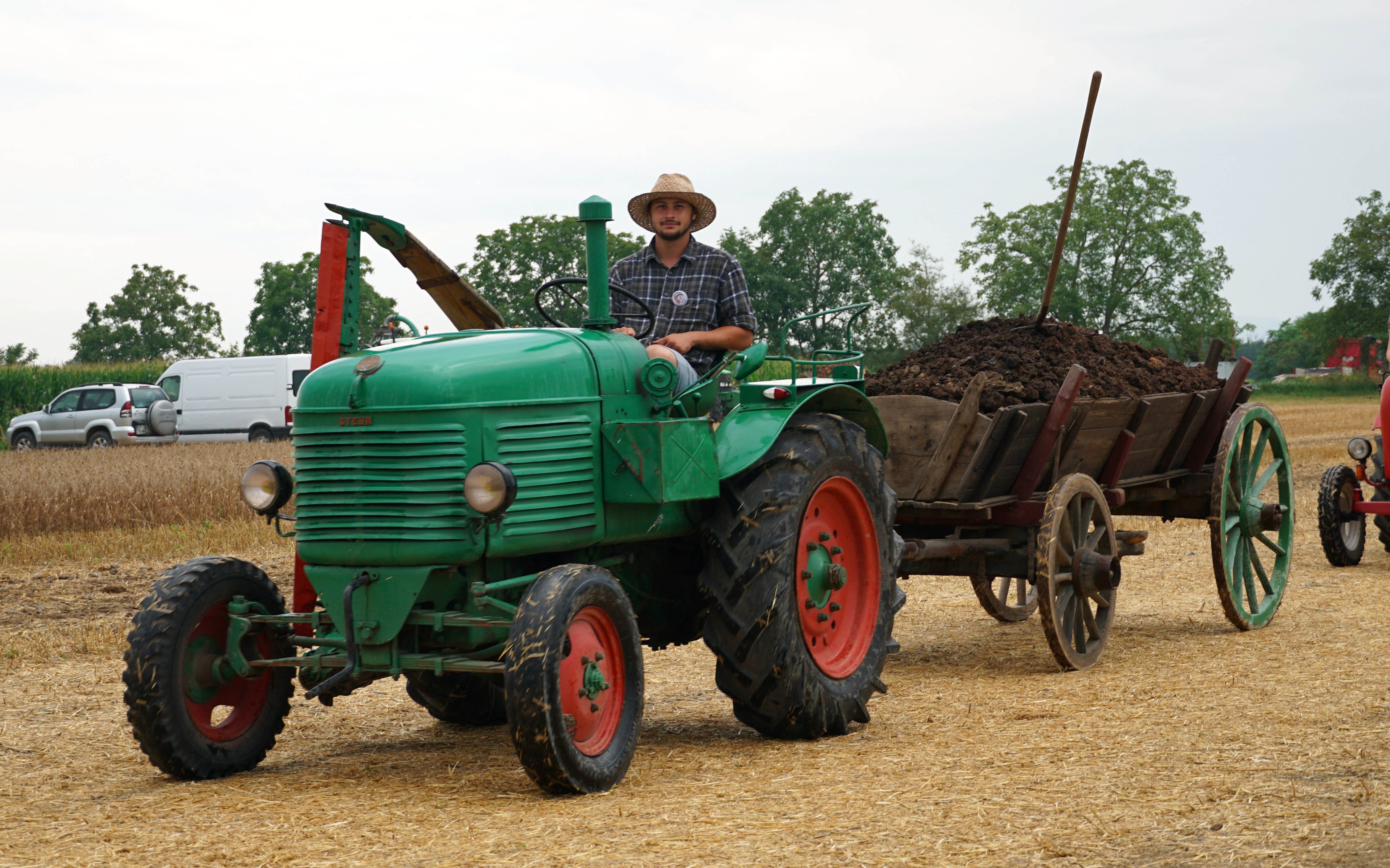 Fertiliser spreading by hand as this Steyr takes to field with muck trailer