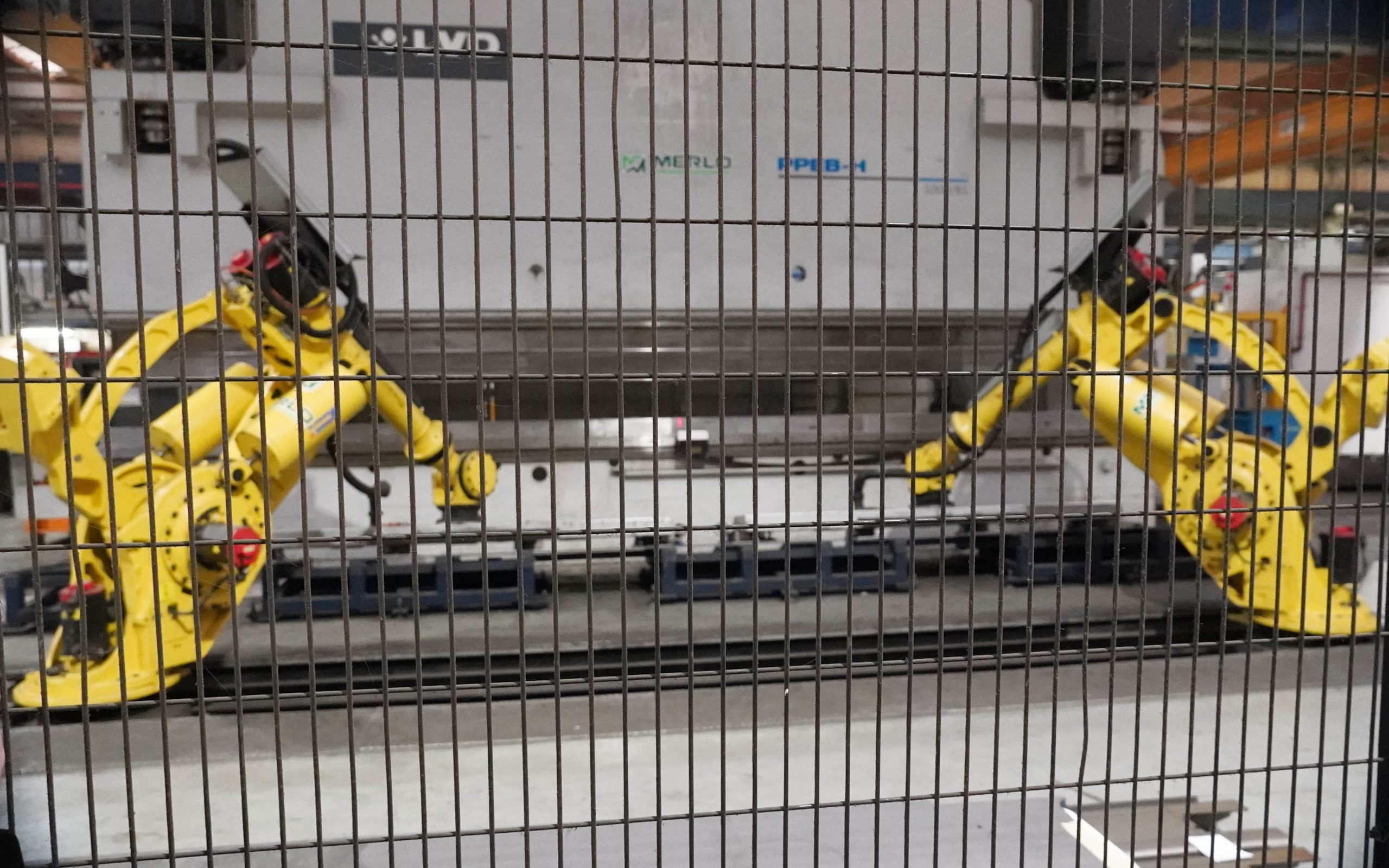 Twin robots developed in in partnership betweeen Merlo and the robotics company load steel plate into a 1,000t press to create a boom section