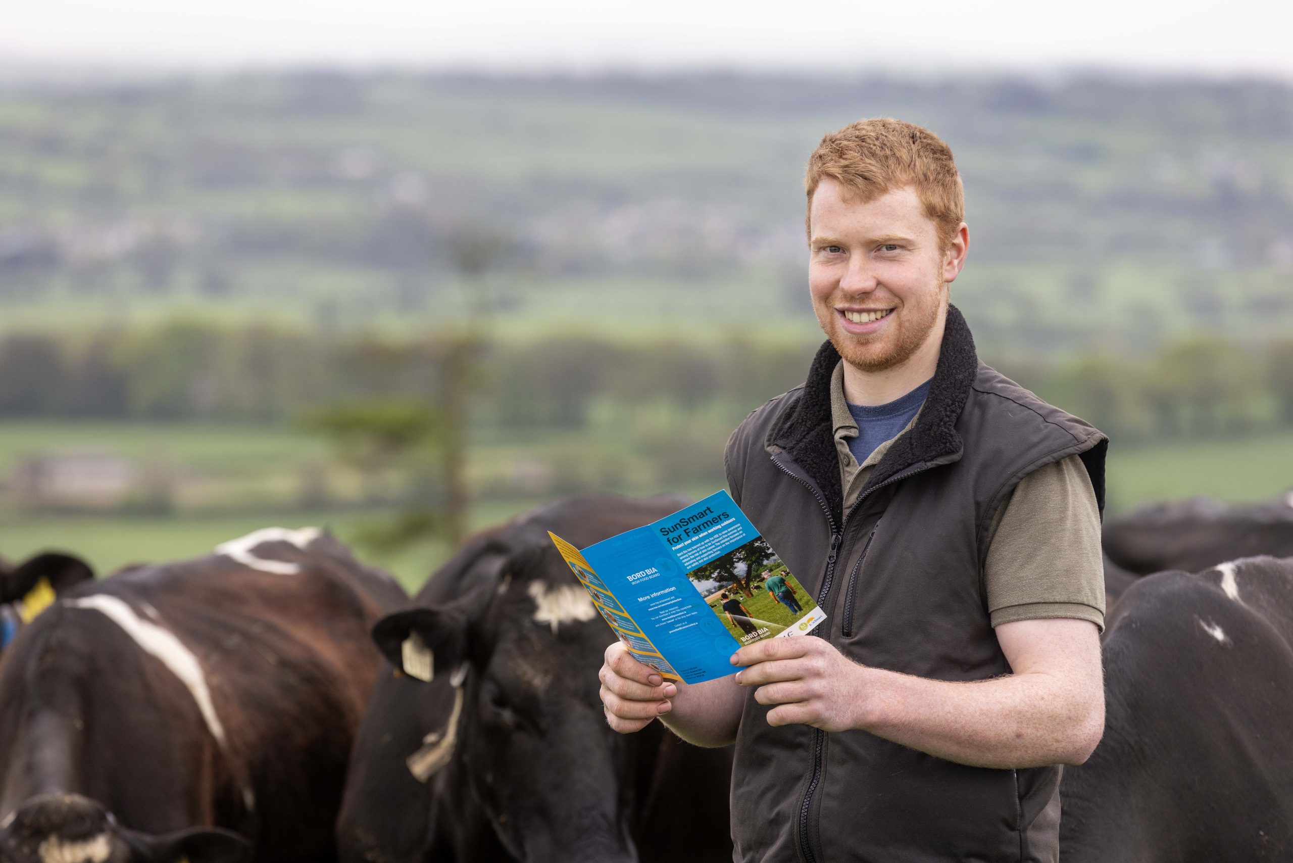 Farmer Ross Crowe with the SunSmart for Farmers leaflet