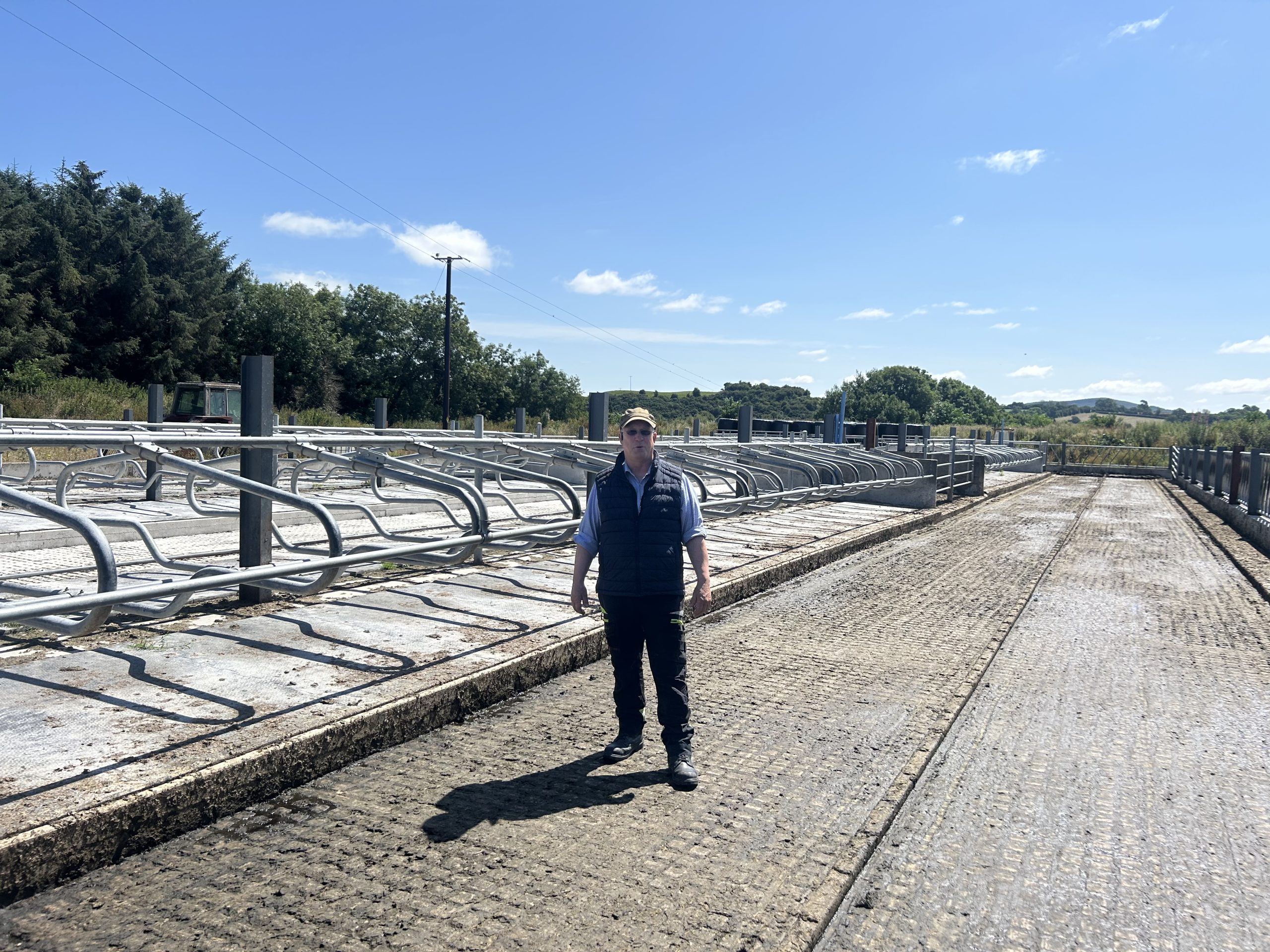 Eugene Lawler standing with his topless cubicles on his farm