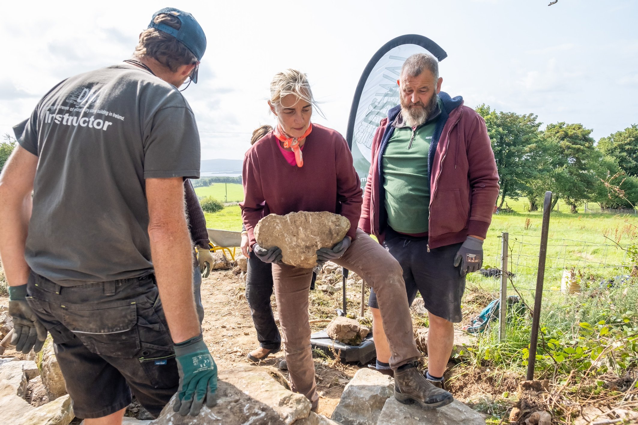 Ken Curran from DSWAI (Dry Stone Wall Association of Ireland) tutoring Creative Farming ambassadors, Margaret Edgill and Declan Houlihan, constructing a stone bench on Brookfield Farm. Horseshoe stone viewing bench - Lough Derg 180, designed by Elements of Action. Source: Kerry Kissane