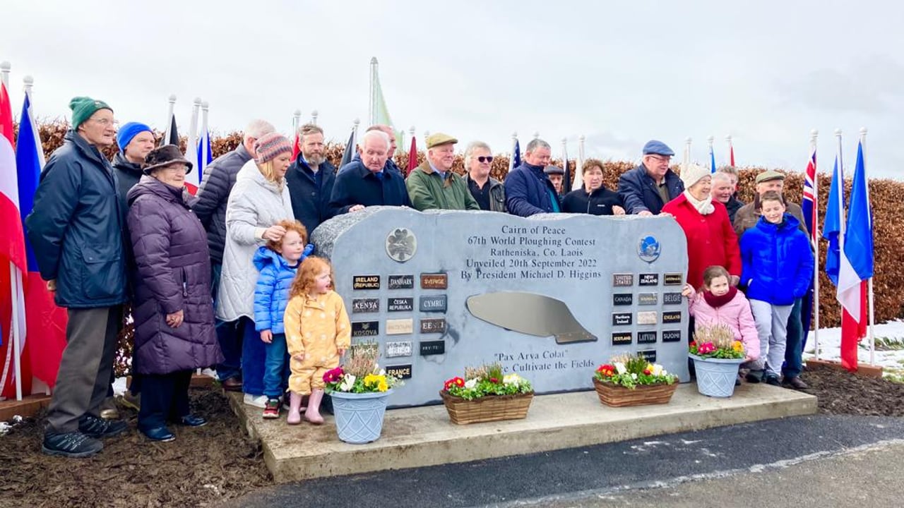 Farmers who contributed land to the site of the 2022 World Ploughing Contest in Co. Laois stand by the commemoration monumnet. Image: Agriland