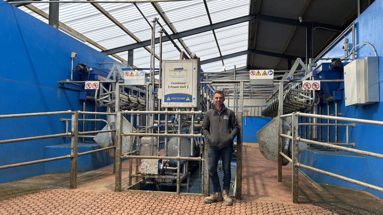Conor Mulcahy standing with his 14-unit DairyMaster Swiftflo parlour