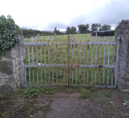 Farmyard wrought iron gates and stone piers preserved