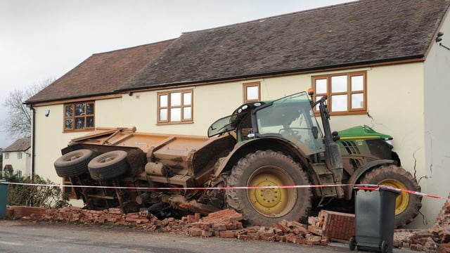 Tractor towing a trailer crashes through the front of a house